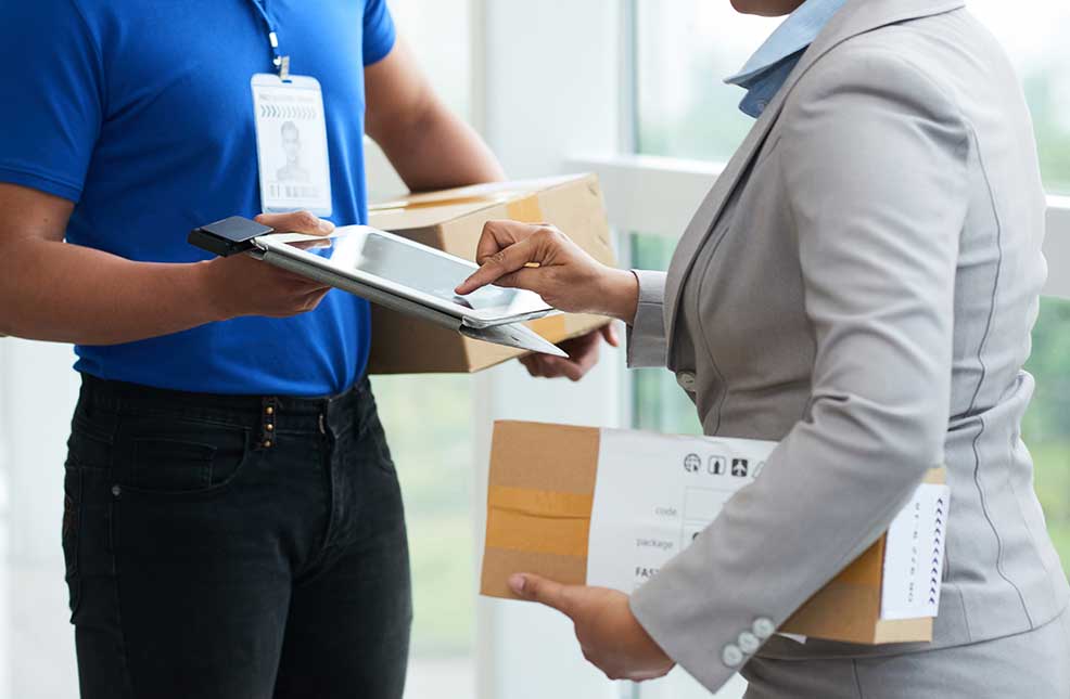 woman checking details on a tablet held by a delivery person